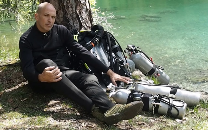 Achim Schlöffel sitting under a tree with stage tanks.